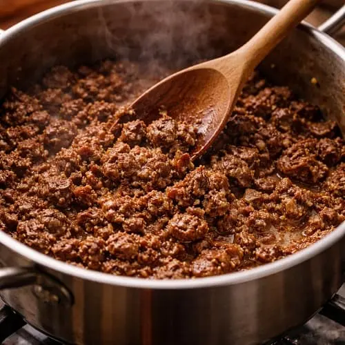Hackfleisch wird portionsweise im großen Topf kräftig angebraten, bis Röstaromen entstehen