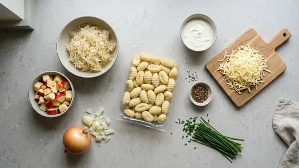 Zutaten für schnelle Gnocchi-Pfanne: Gnocchi, Sauerkraut, Apfel, Schmand, Bergkäse, Kümmel und Kräuter
