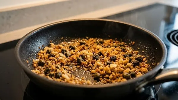 Kapernbrösel werden in einer Pfanne gold geröstet und später über Quesadillas gestreut